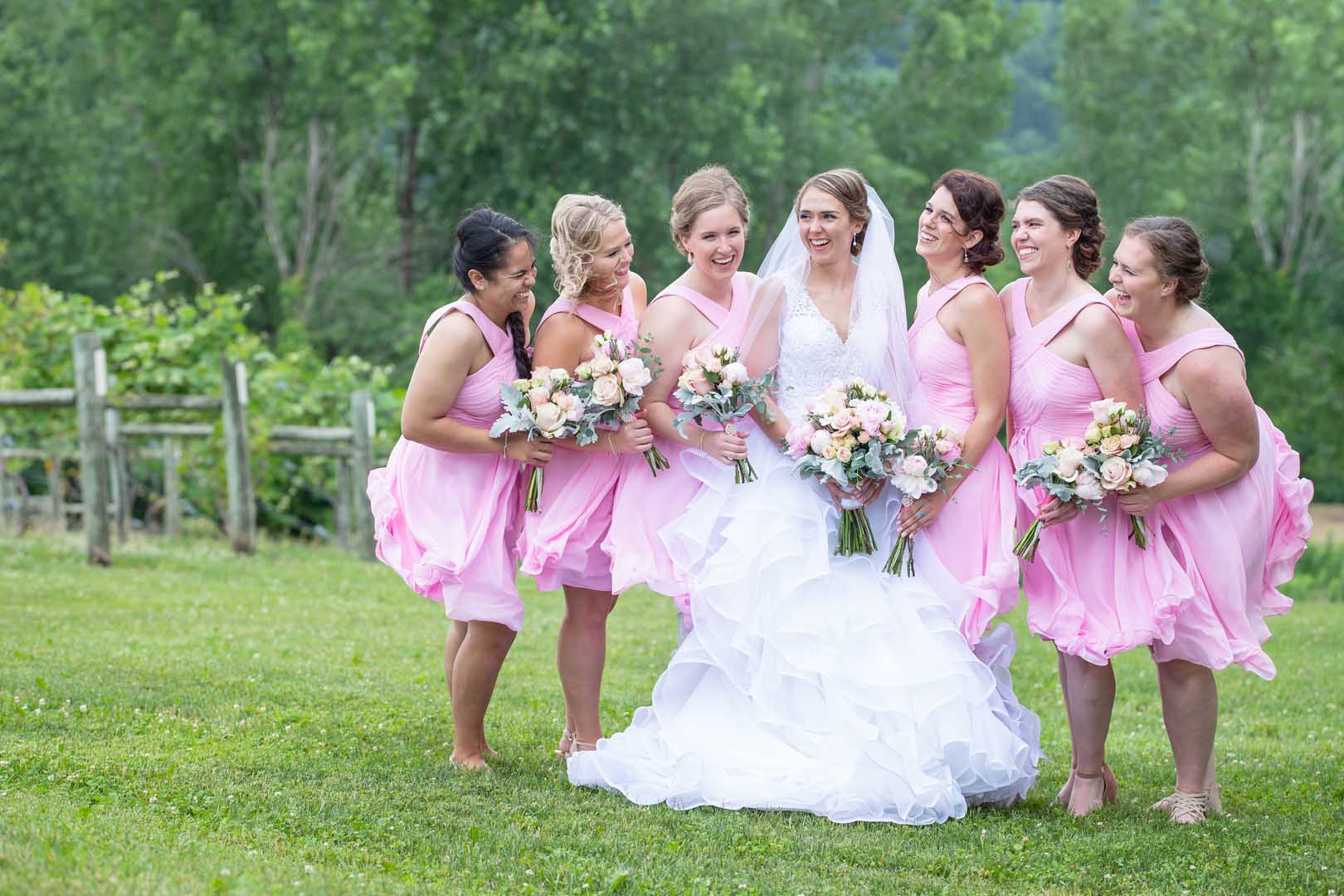 Bridesmaids laughing together outside before the wedding ceremony