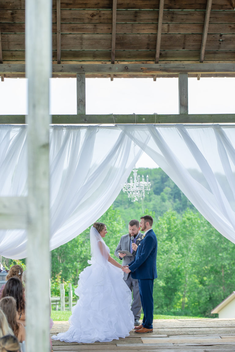 Bride and groom at wedding ceremony in a wooden barn in Cannon Falls, MN